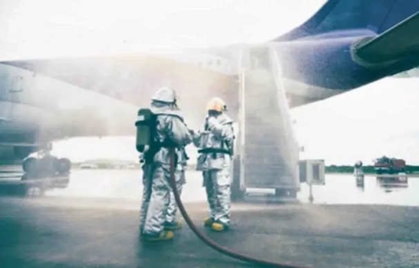Firefighters spraying water on aircraft.