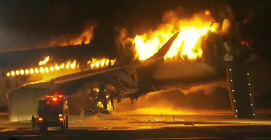 Airplane engulfed in flames at night.